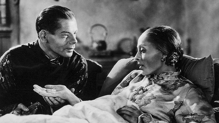 Un hombre atiende a una mujer en la cama en La buena tierra.