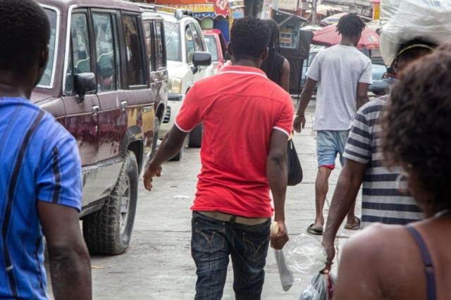 Un hombre camina con un machete en puerto príncipe