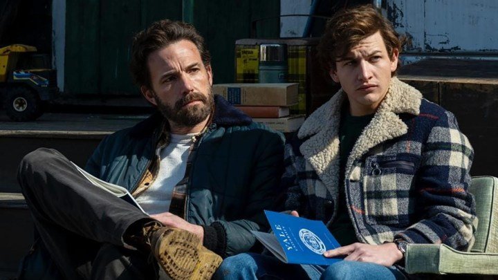 Ben Affleck y un joven se sientan juntos a leer panfletos de Yale en una escena de The Tender Bar.