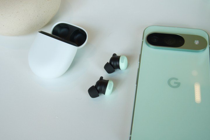 Los Google Pixel Buds Pro 2 junto a su estuche de carga y un Pixel 9.