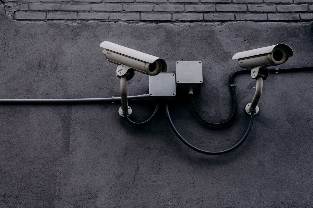 Dos cámaras de vigilancia de bajo coste instaladas en el exterior de un edificio, ejemplificando un sistema de seguridad doméstico económico.
