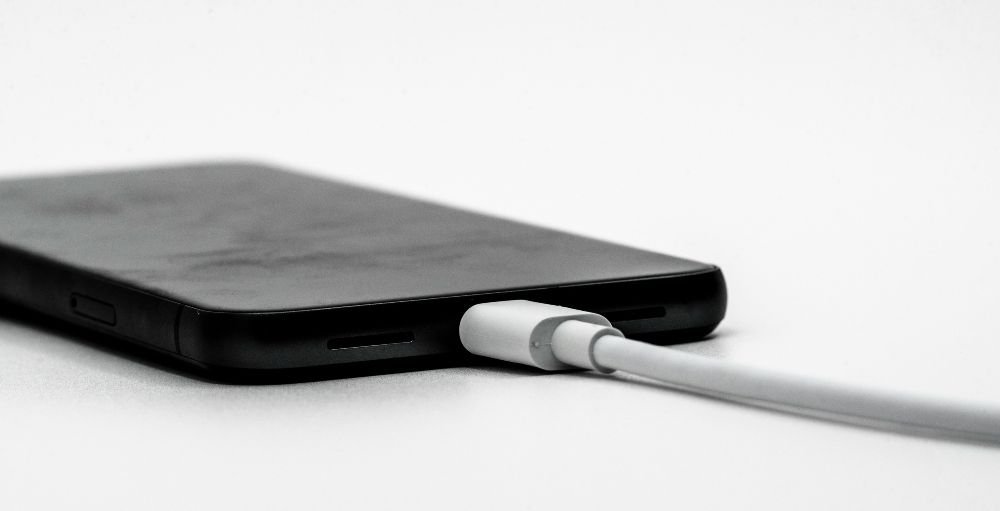 Diagrama conceptual de un ataque de juice jacking, donde un teléfono se conecta a un puerto USB malicioso que extrae datos mientras simula una carga normal.