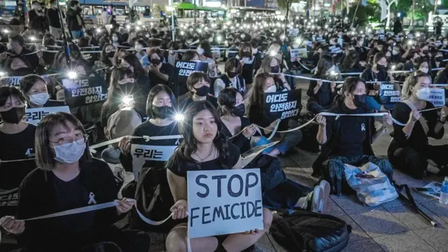 En una protesta en Seúl en 2022, una mujer sostiene un cartel que dice «detengan el feminicidio».