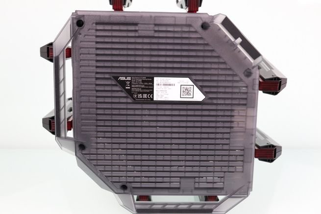 Parte inferior del router ASUS GT-BN98 con rejilla de ventilación y etiqueta de especificaciones técnicas.